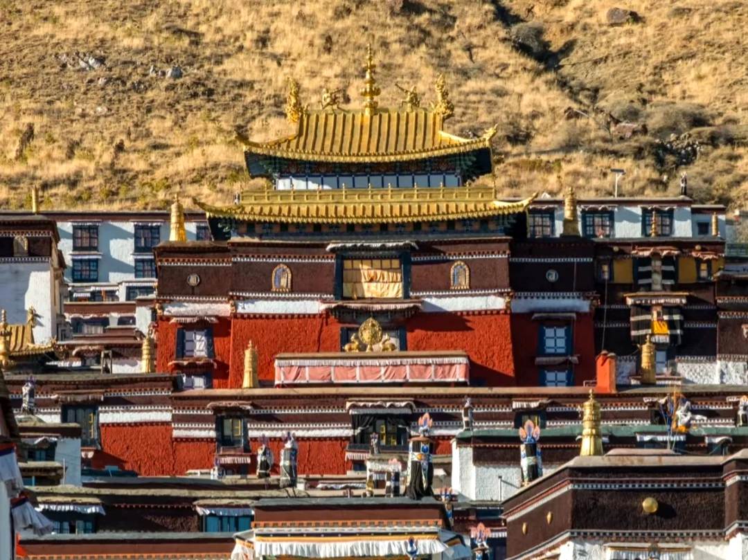 金色的陽光傾瀉而下,温柔地鋪滿紥什倫布寺的紅墻金頂,每一片瓦都像被點燃的佛光。